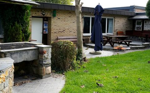 La terrasse en pierre bleue devant la salle, avec le jardin.